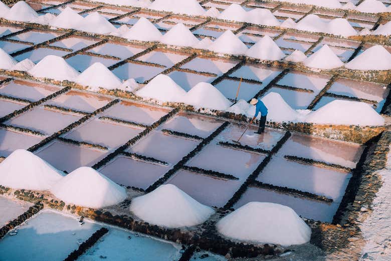 Vista aérea de las Salinas de Janubio con un salinero trabajando